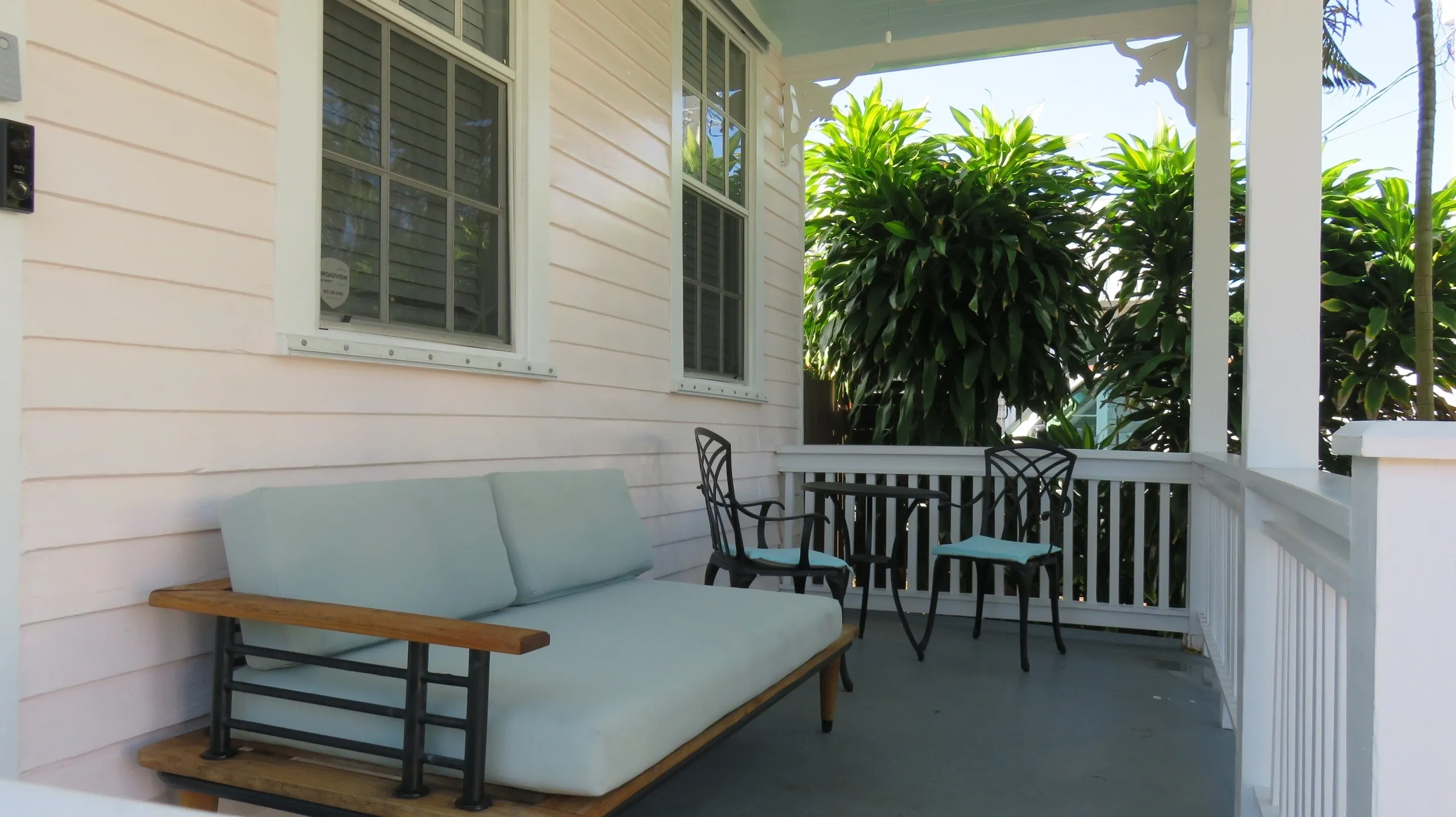 Cozy porch with seating and greenery.