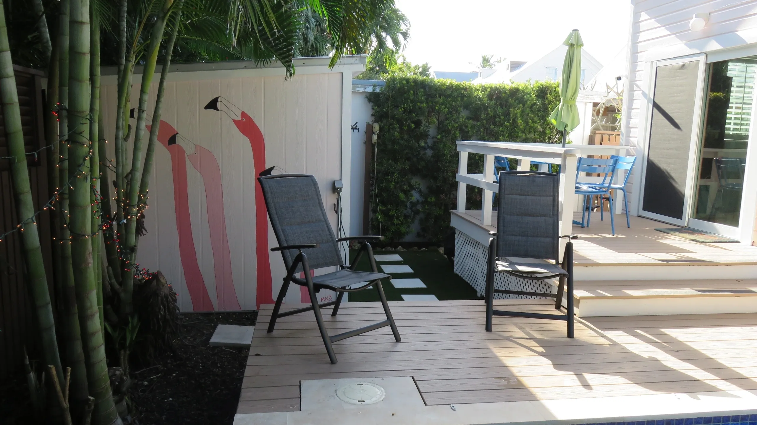 Outdoor patio with chairs and wall art.