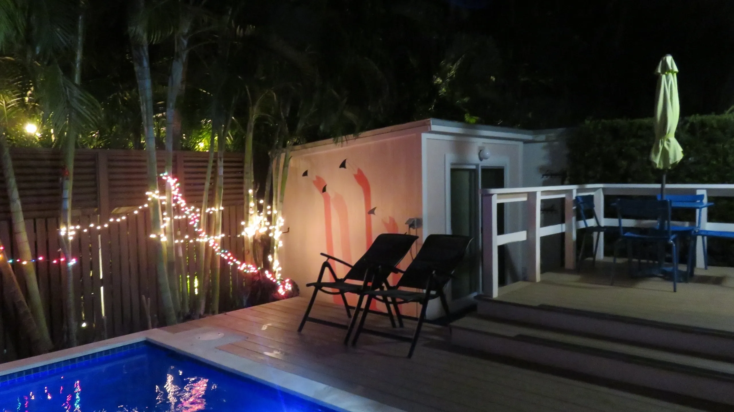 Poolside deck with lights and lounge chairs.