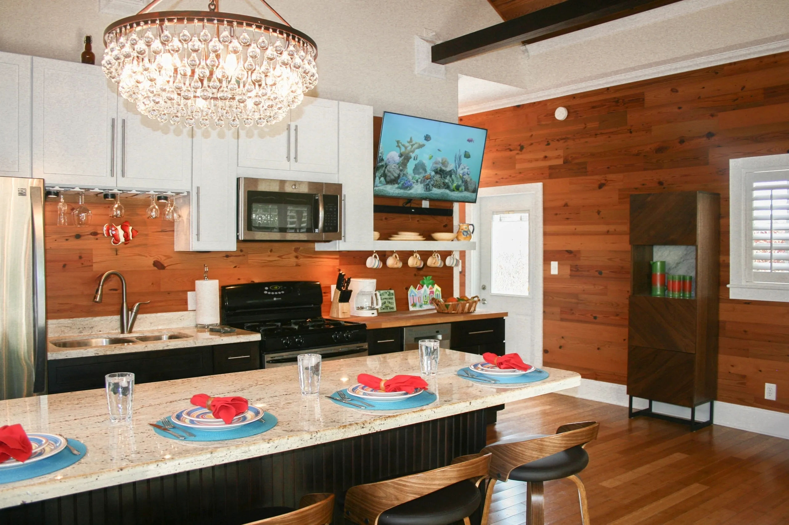 Modern kitchen with chandelier and island seating.