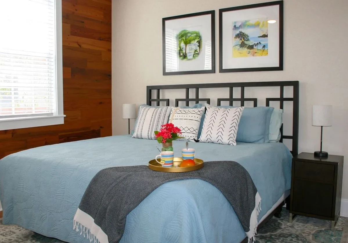 Cozy bedroom with blue bedding and art.