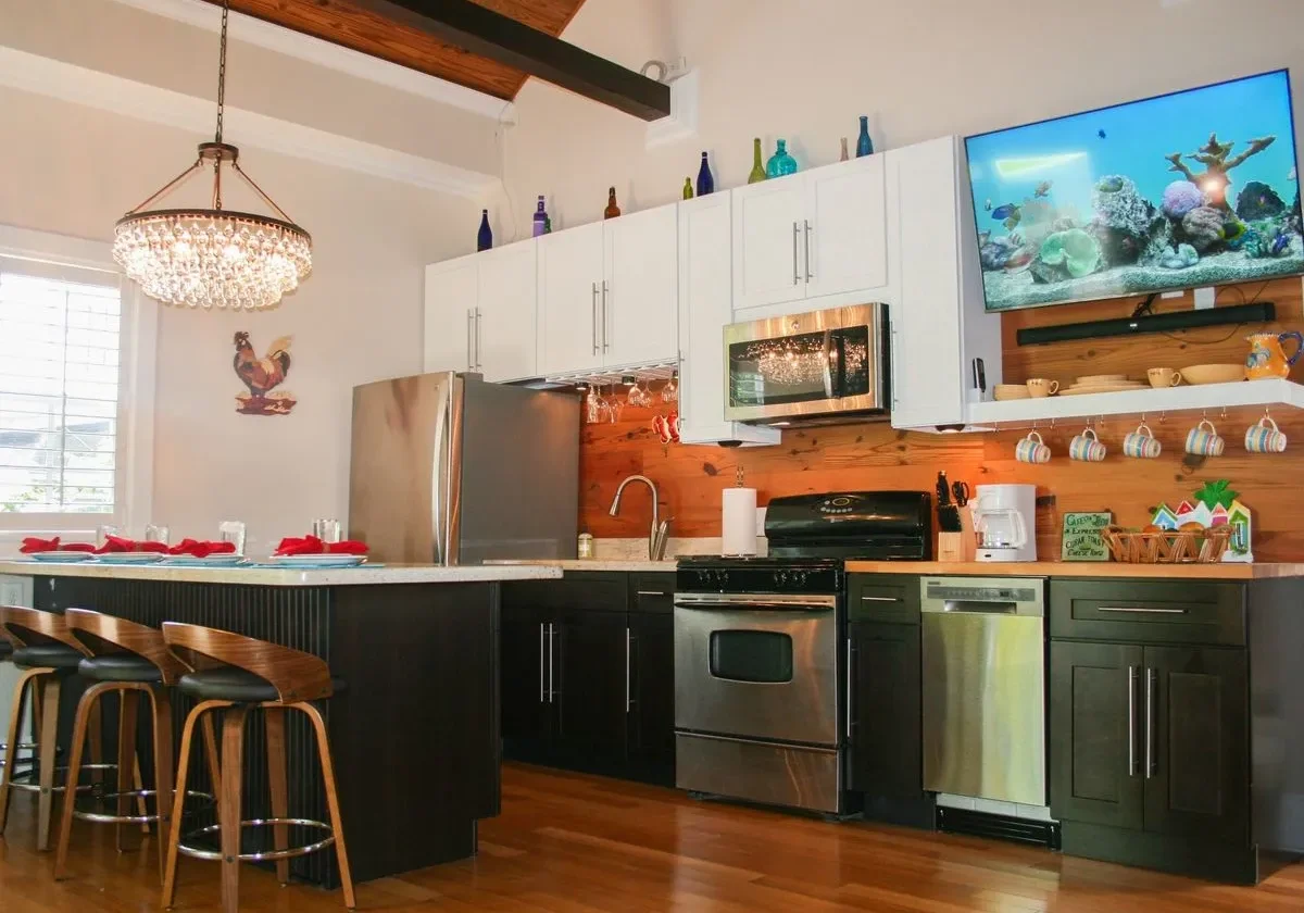 Modern kitchen with island and hanging lights.