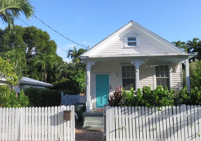 Small house with white picket fence.
